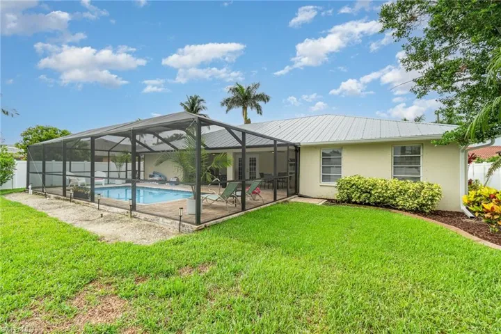 Fenced Back yard showing screened pool area