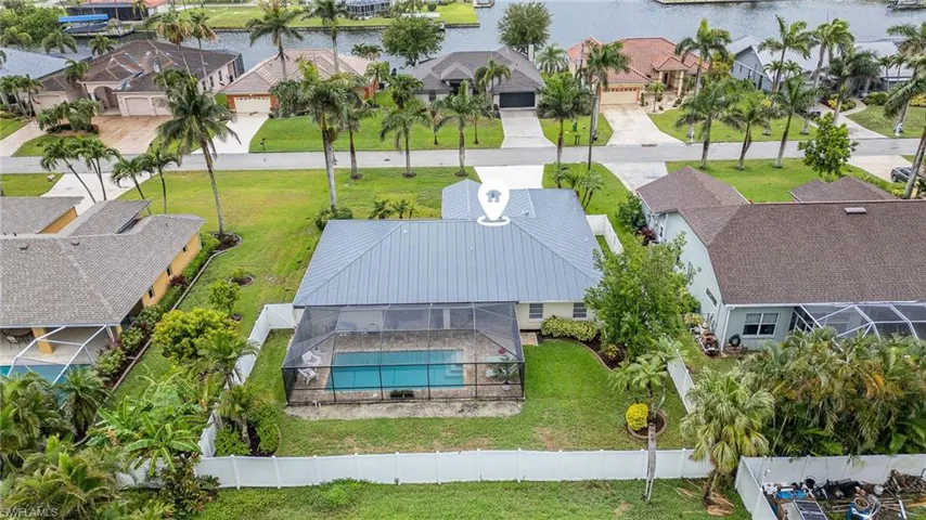Aerial perspective with Gulf Access homes across the street, shows fenced in area and private back yard
