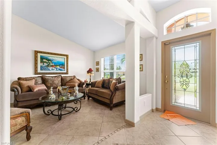 Entry foyer featuring a decorative glass panel front door with a transom window