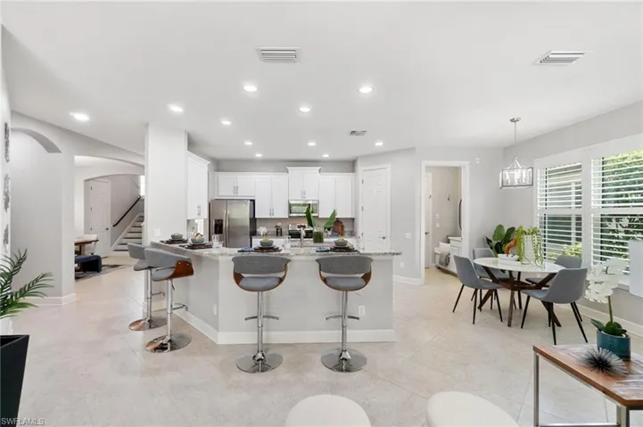 Kitchen with white cabinetry, breakfast bar and eat-in kitchen area offer plenty of options for a quick bite