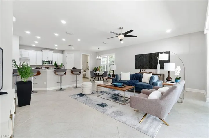 Living room with light tile patterned floors and ceiling fan