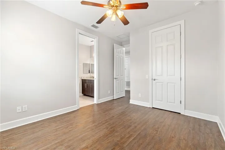 Unfurnished bedroom 4 with ensuite bath, ceiling fan, and wood-type flooring
