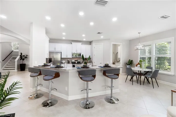 Kitchen featuring appliances with stainless steel finishes, a breakfast bar area and eat-in dining space