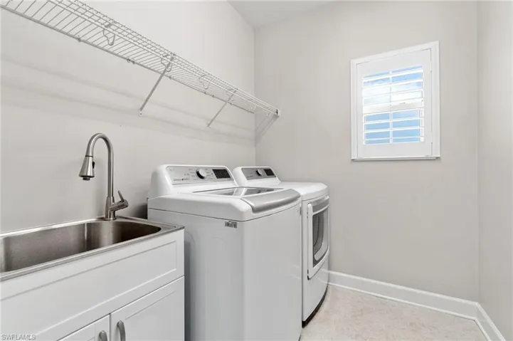Convenient upstairs Laundry area with sink, cabinets, and independent washer and dryer