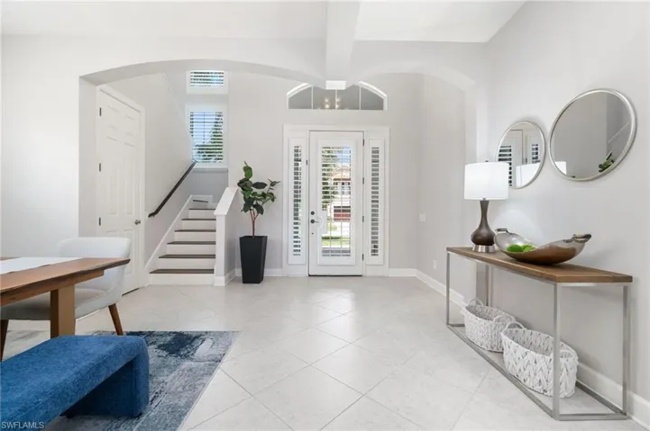 Foyer entrance featuring beam ceiling and light tile patterned floors