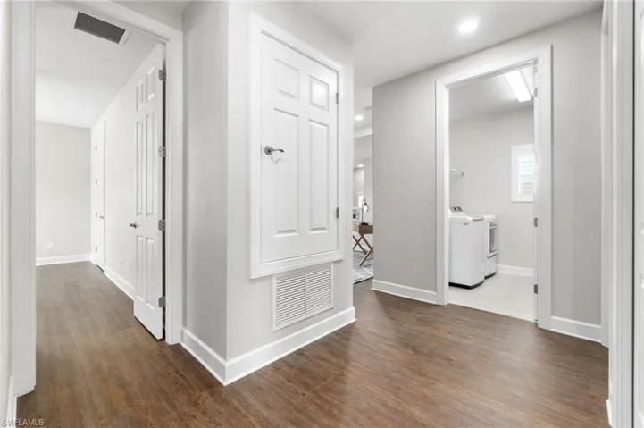 Situated off the upstairs loft; is a Corridor with washer and clothes dryer and dark hardwood / wood-style flooring