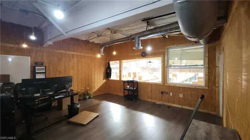 Office area with wood finished floors and wood walls