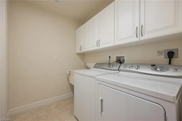 Laundry room with overhead cabinets and a laundry sink