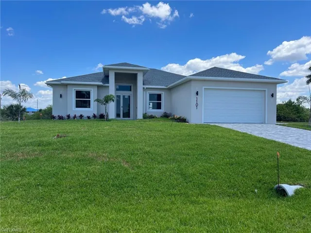 View of front of property with a front yard and a garage