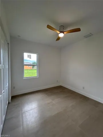 Tiled spare room with ceiling fan