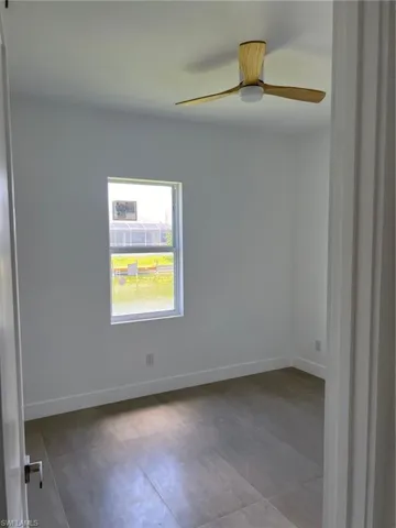 Tiled empty room featuring ceiling fan