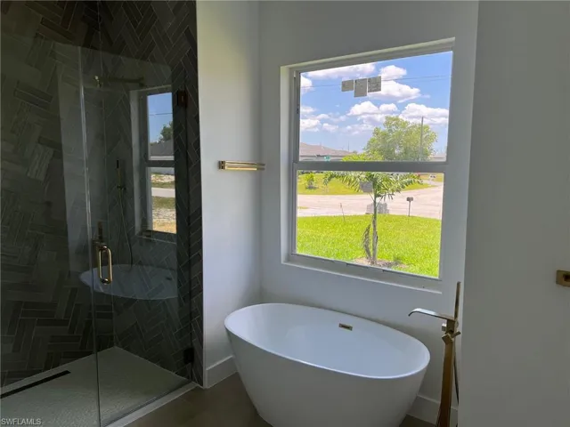 Bathroom with tile flooring and plus walk in shower