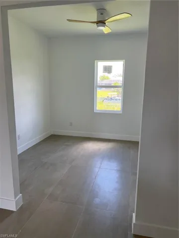 Unfurnished room with tile floors and ceiling fan