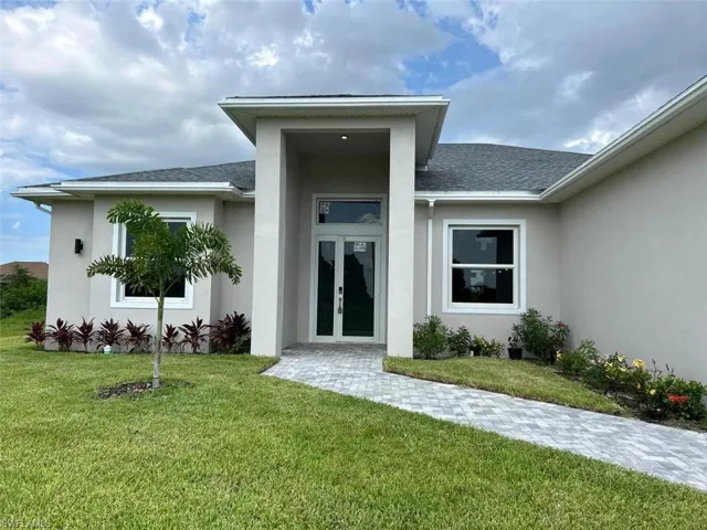 Entrance to property with a yard and french doors