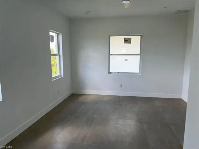 Unfurnished room with dark tile flooring