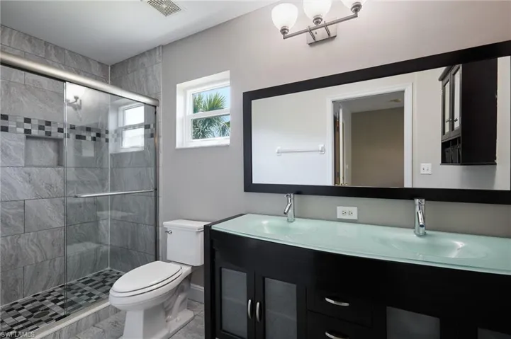Bathroom with a sink, toilet, and a shower stall