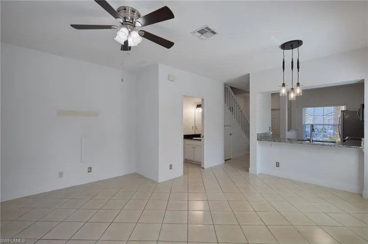 Unfurnished living room with visible vents, stairway, baseboards, and light tile patterned flooring