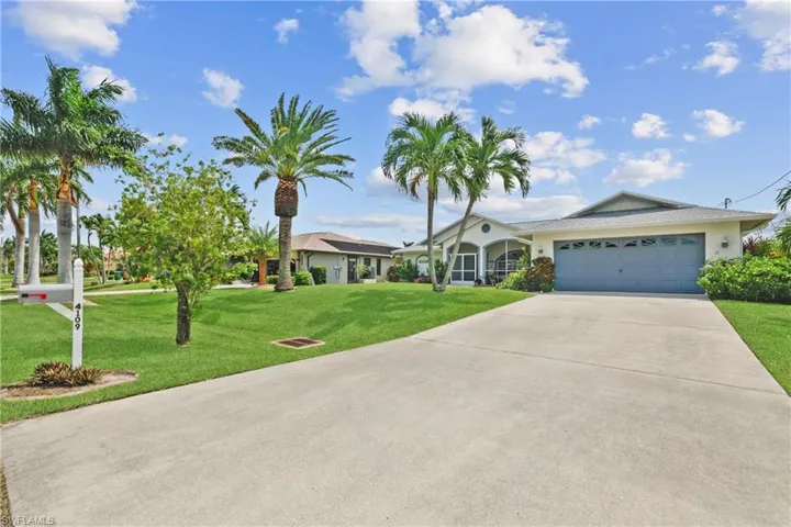 Single story home featuring a garage and a front lawn