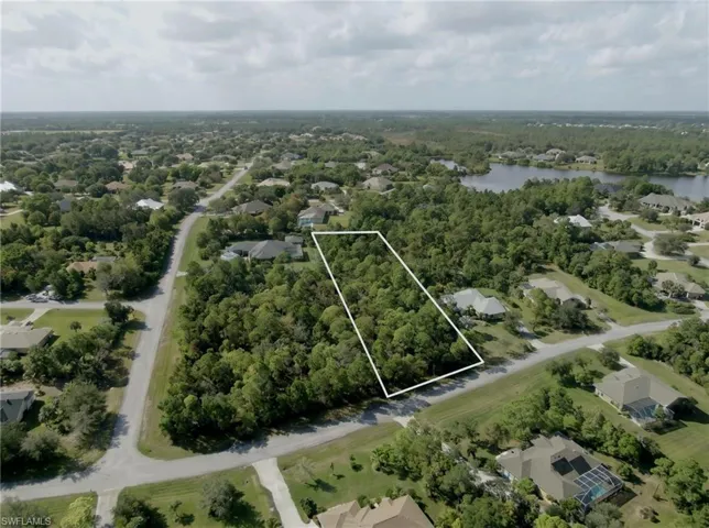 Expansive undeveloped lot featuring mature trees and established roads