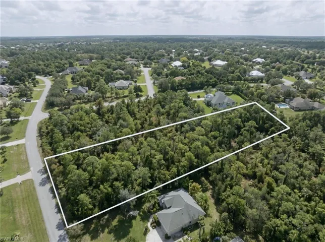 Wooded parcel with surrounding residential properties and paved roads