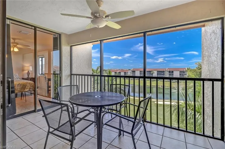 Sunroom / solarium with ceiling fan and a water view