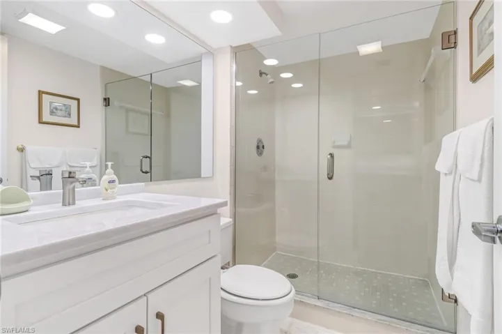 Bathroom with tile patterned flooring, vanity, toilet, and a shower with door