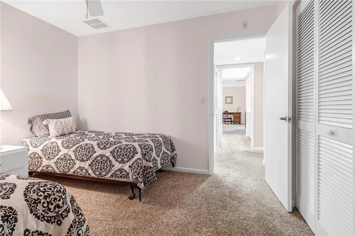 Bedroom with ceiling fan, a closet, and carpet
