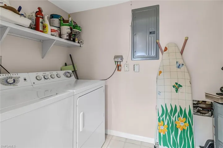 Laundry room with washer and clothes dryer and electric panel