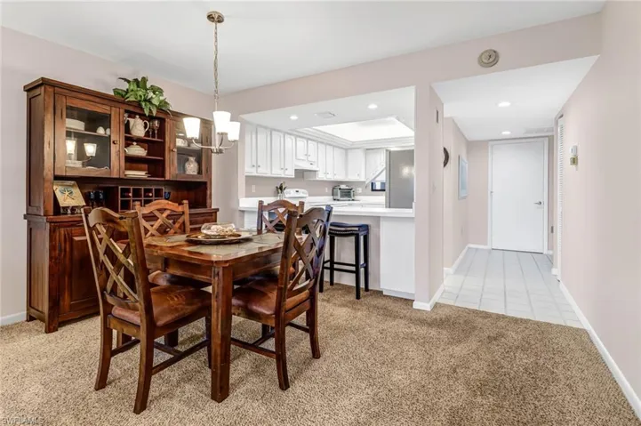 Carpeted dining room with a chandelier