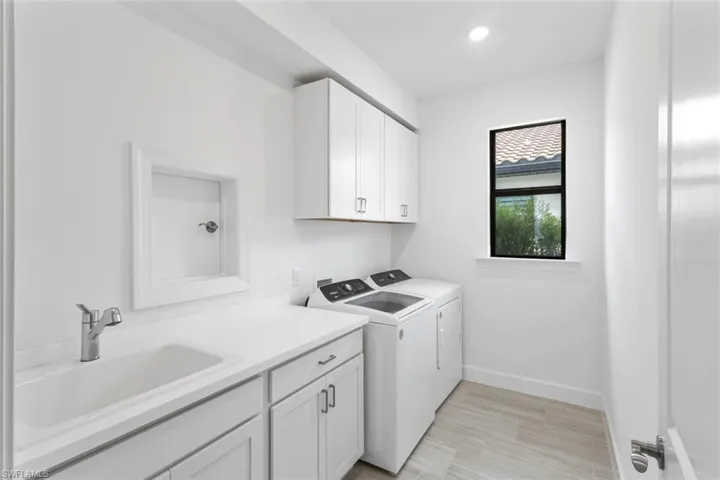 Laundry room with cabinet space, washing machine and dryer, and recessed lighting
