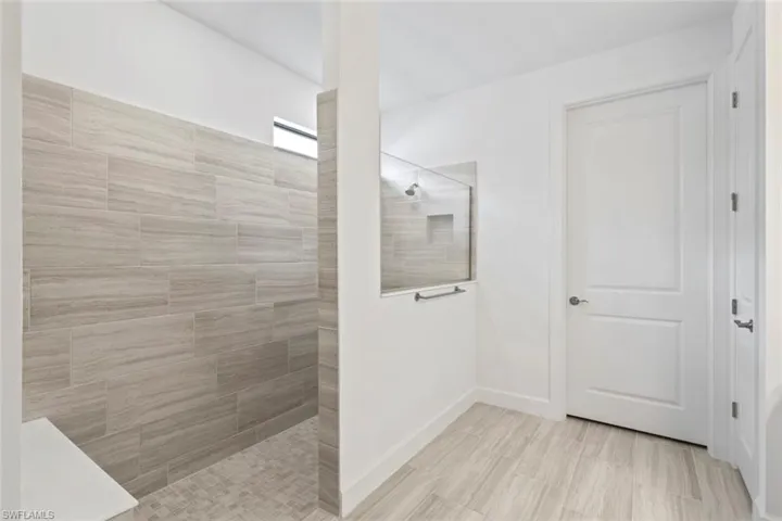 Bathroom featuring a walk in shower and baseboards