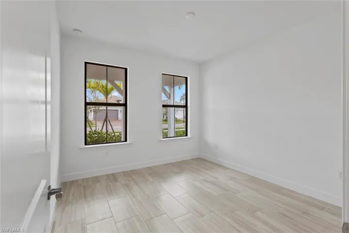 Empty room with baseboards and wood finish floors