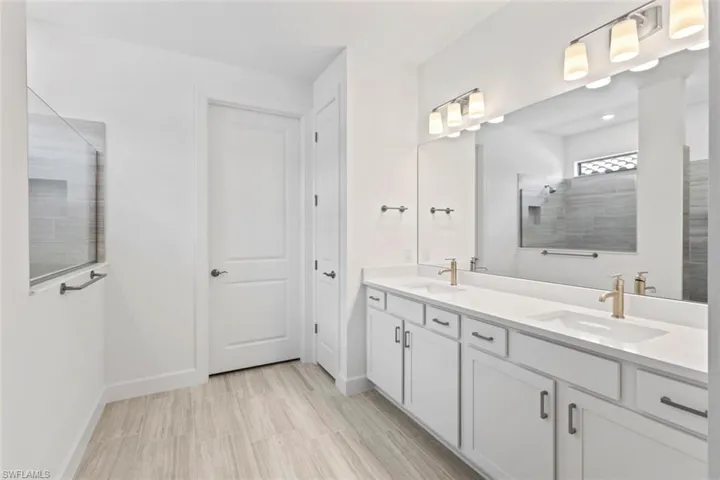 Full bathroom with double vanity and a walk in shower