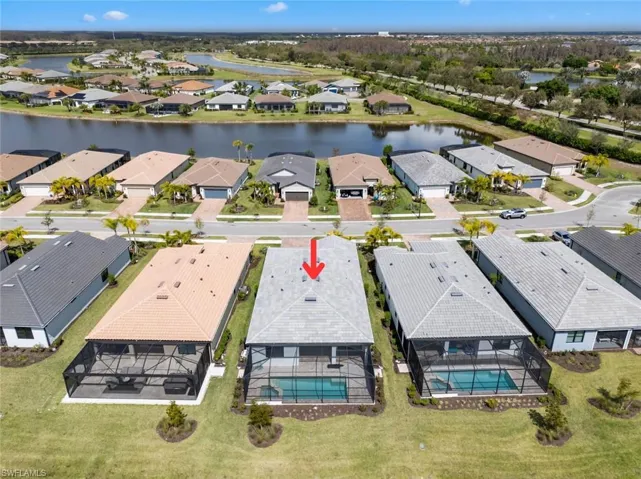 Aerial view of residential area featuring a nearby body of water