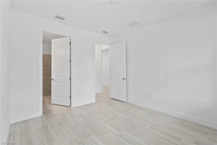 Unfurnished bedroom featuring baseboards and ensuite bath