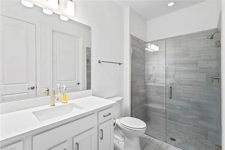 Full bath with a shower stall and vanity