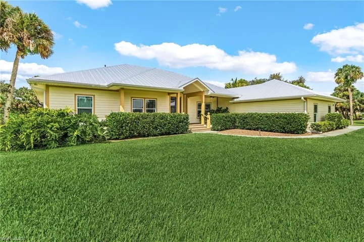 Ranch-style home with a front lawn and a metal roof