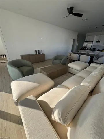 Open-concept living area with light wood-finish flooring, a contemporary ceiling fan, and recessed lighting