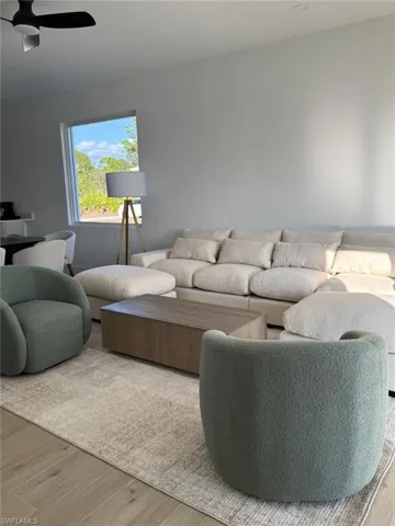 Open-concept living space with light wood-finish flooring, recessed lighting, and a contemporary ceiling fan