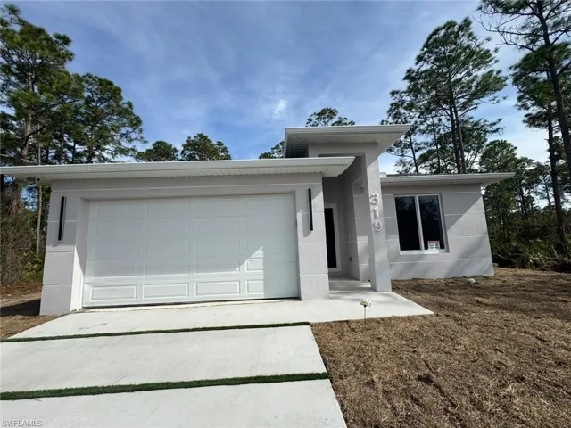 Contemporary single-story residence with a textured light gray exterior and white trim