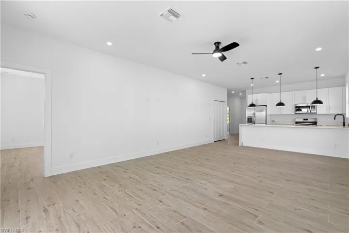 Open-concept living space featuring wood-finish flooring, recessed lighting, and a contemporary ceiling fan
