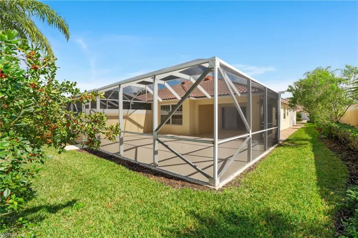 Rear view of property with a patio, a yard, and glass enclosure