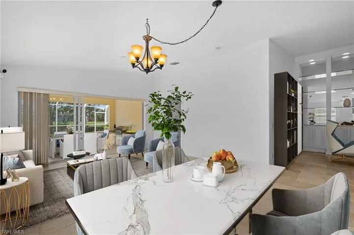 Dining area with an inviting chandelier, french doors, and light tile patterned floors