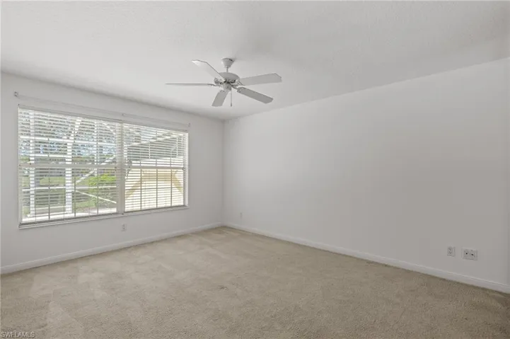 Carpeted empty room featuring ceiling fan and a textured ceiling