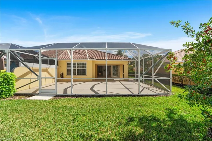 Back of house with a patio, a yard, and glass enclosure