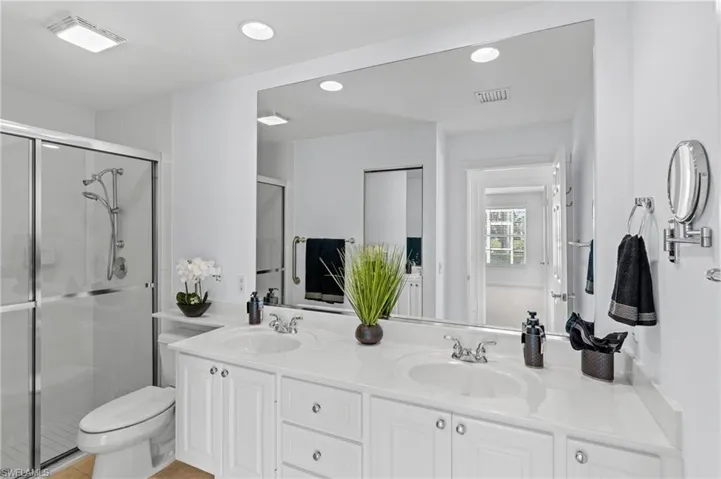Bathroom featuring vanity, toilet, and walk in shower