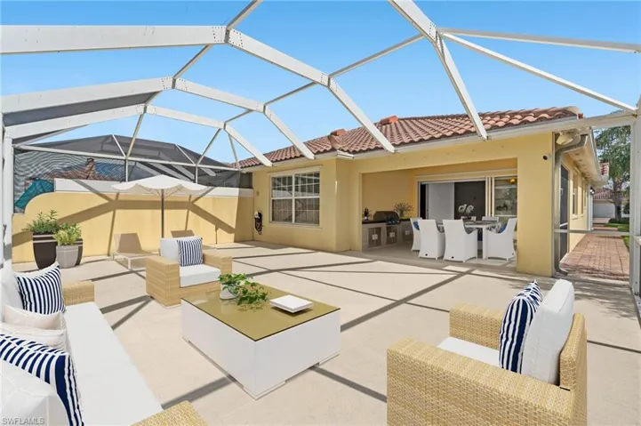 Back of property with an outdoor living space, a patio, and glass enclosure