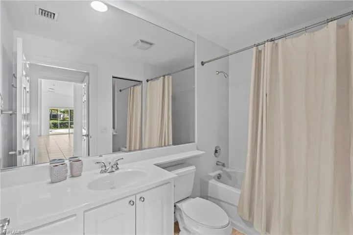 Full bathroom with vanity, toilet, and shower / bathtub combination with curtain