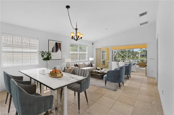 Tiled dining space with vaulted ceiling and a chandelier