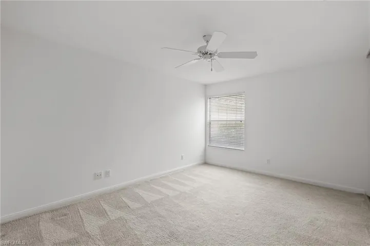 Unfurnished room featuring light colored carpet and ceiling fan